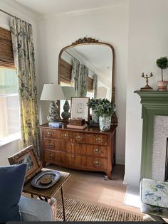 a living room filled with furniture and a large mirror on top of a dresser next to a fire place