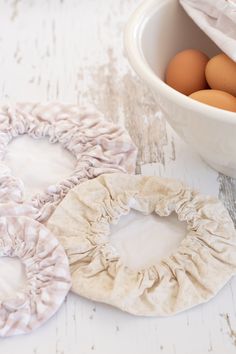 three scrunffles are next to a bowl of eggs on a white table