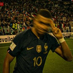 a blurry photo of a soccer player on his cell phone in front of an audience