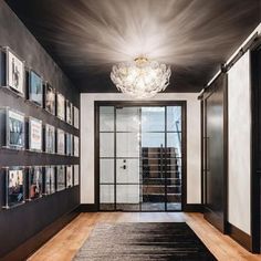 a hallway with pictures on the wall and a chandelier