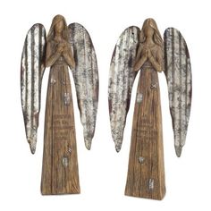 two wooden angel figurines sitting next to each other on top of a white background