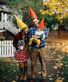 a man and woman are dressed up as gnomes with baby in their arms while standing next to each other