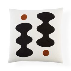 a black and white pillow with an orange dot on the bottom, two wavy shapes