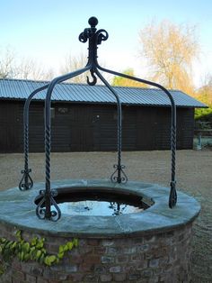 an iron sculpture in the middle of a brick fire pit with water running through it