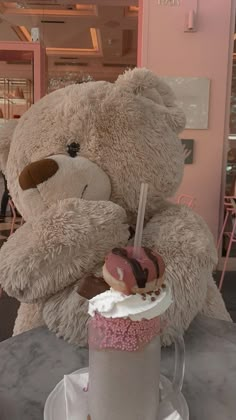 a large teddy bear sitting next to a cupcake