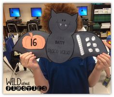 a young boy holding up a cut out of a cat