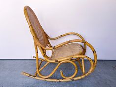 a wicker rocking chair sitting against a wall