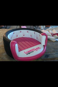 a pink and white dog bed sitting on top of a wooden table