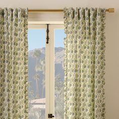 an open window with green and blue curtains in front of it, looking out onto the mountains