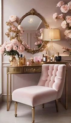 a pink chair sitting in front of a mirror next to a table with flowers on it