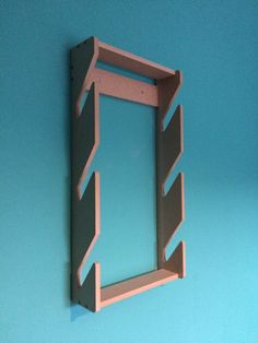 a wooden shelf with an open window on the side against a blue wall in front of it