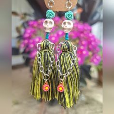 a pair of earrings with tassels hanging from it's earring hooks