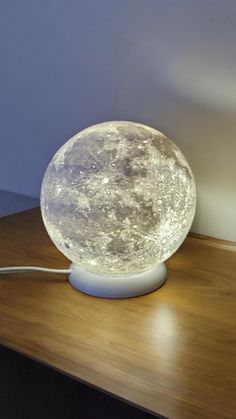 an illuminated moon lamp on a wooden table