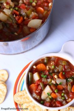 a bowl of vegetable soup with crackers on the side