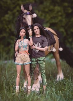 two dolls standing next to a horse in the grass with trees in the background and one doll has her hand on the horse's bridle