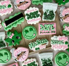 some decorated cookies are sitting on a wooden table with green and pink frosted decorations