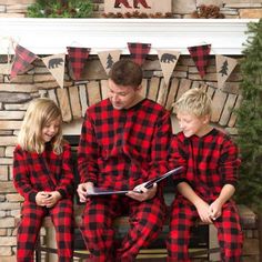 a man and two children wearing matching red and black flannel pajamas