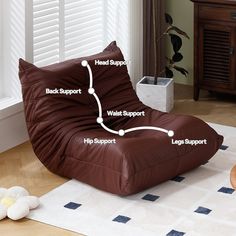 a brown bean bag chair sitting on top of a wooden floor next to a white rug