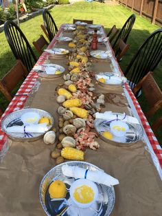 a long table covered in plates and corn on the cob