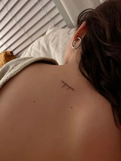 a woman with a cross tattoo on her back