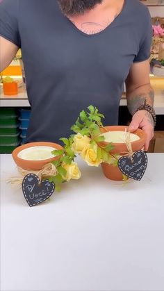 a bearded man is holding two flower pots