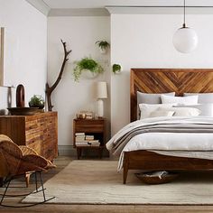 a bed room with a neatly made bed next to a night stand and dressers