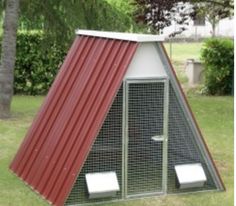 a chicken coop with a red roof in the grass