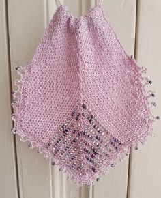 a pink crocheted rug sitting on top of a tile floor next to a toilet