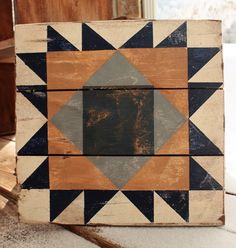 a wooden block with an image of a diamond on the front and sides, sitting on top of a carpeted floor