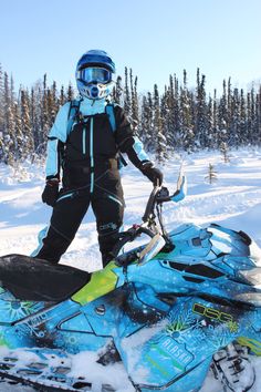 a person standing next to a snowmobile in the snow