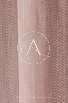 the letter a is inscribed in white on a pink background