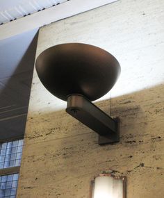 a street light mounted on the side of a building next to a window with a skylight above it