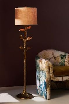 a lamp sitting next to a chair in a room with purple walls and flooring