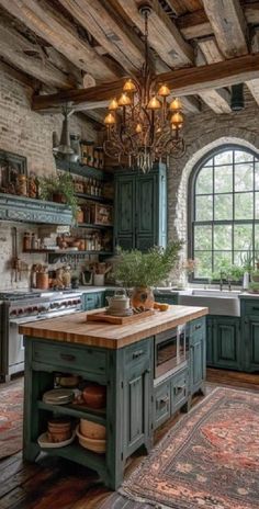 an old fashioned kitchen with green cabinets and chandelier hanging from the wooden ceiling