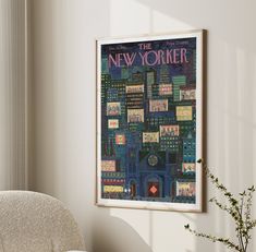 a framed poster hangs on the wall above a chair and vase with flowers in it