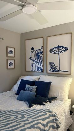 a bedroom with two pictures on the wall above the bed and an umbrella over the bed