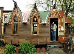 a man standing in the doorway of a tiny house