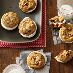 chocolate chip cookies and marshmallows on a baking tray next to a glass of milk