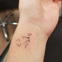 a small dog tattoo on the wrist