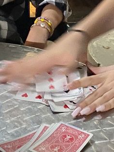 people are playing cards at a table with their hands in the air and on top of each other