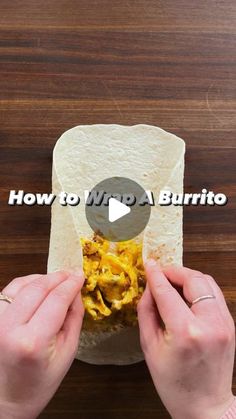 someone is making a burrito with chicken and cheese in it on a wooden table