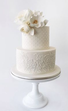 a three tiered cake with white flowers on top