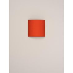 an orange lamp shade on a white wall