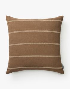 a brown and white striped pillow on a white background