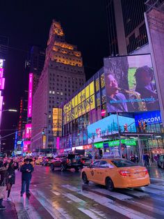 a busy city street at night with neon lights and billboards on the building walls