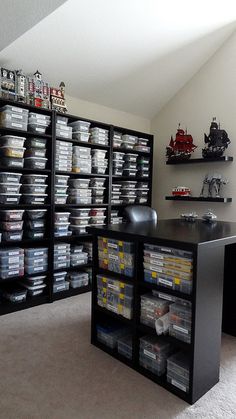 a room filled with lots of boxes and shelves next to a desk in front of a window