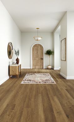 an empty room with wood floors and white walls