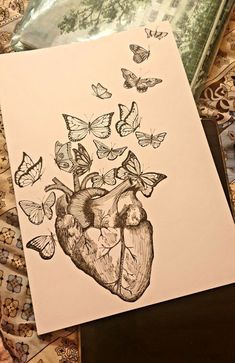 a drawing of a human heart with butterflies flying out of it on top of a piece of paper