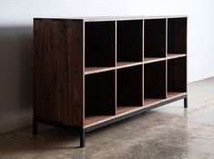 a wooden shelf with several cubes on the bottom and one is black in color