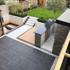 an outdoor patio with steps and seating area next to a small garden in the back yard